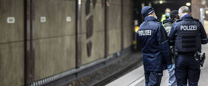 Zwei Polizisten verhaften eine Person in einer U-Bahn-Station